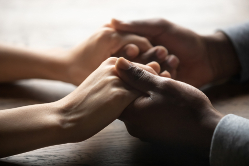 Mixed,Ethnicity,Family,Couple,Holding,Hands,On,Table,,Black,Man